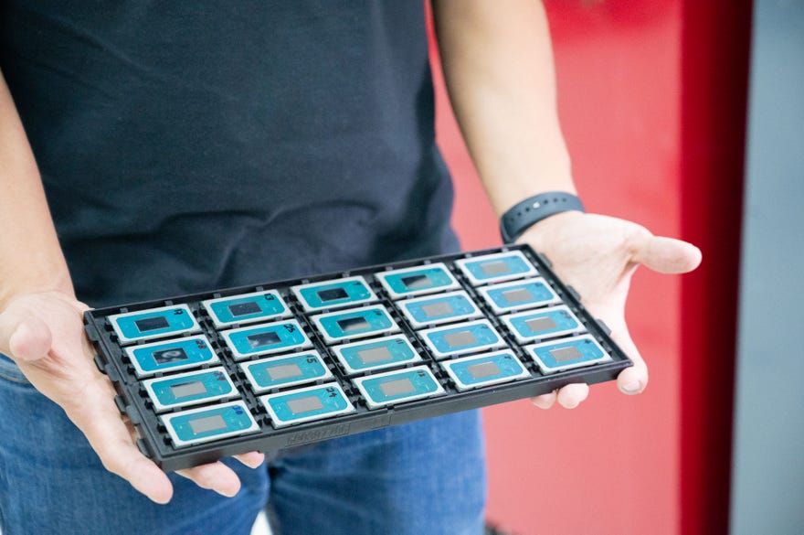 A man holds a tray of Intel Core Ultra CPUs.