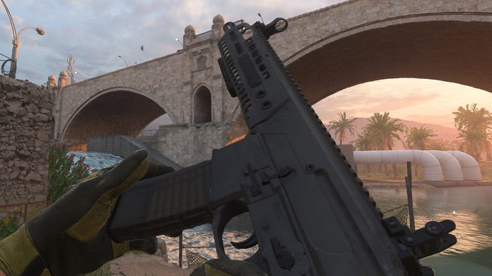 The player in Modern Warfare 2 inspects their weapon, an M13B Assault Rifle.