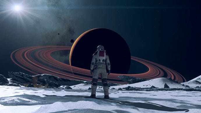 A figure stands on the surface of a moon and looks out towards a ringed planet in the sky in Starfield.